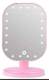 Roze kozmetičko ogledalo sa LED diodama i USB kablom.
