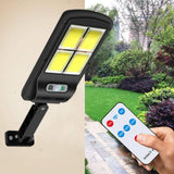 Solarna zidna lampa prikazana kao rasvetno rešenje za dvorište.