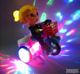 Igračka prikazuje devojčicu koja sedi na biciklu.